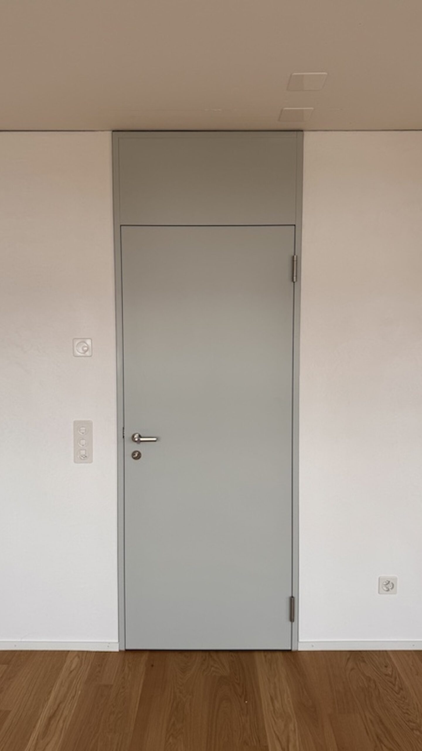 Graue Zimmertüre in weisser Wand